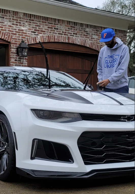 Father & Son's Mobile Detailing working on a white Chevrolet Camaro ZL1 in a customer's driveway