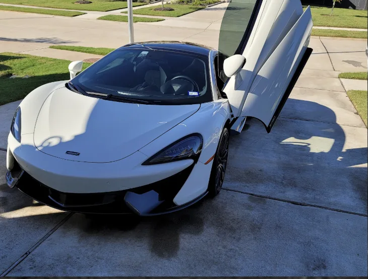 White McLaren 570GT in a driveway after a detail