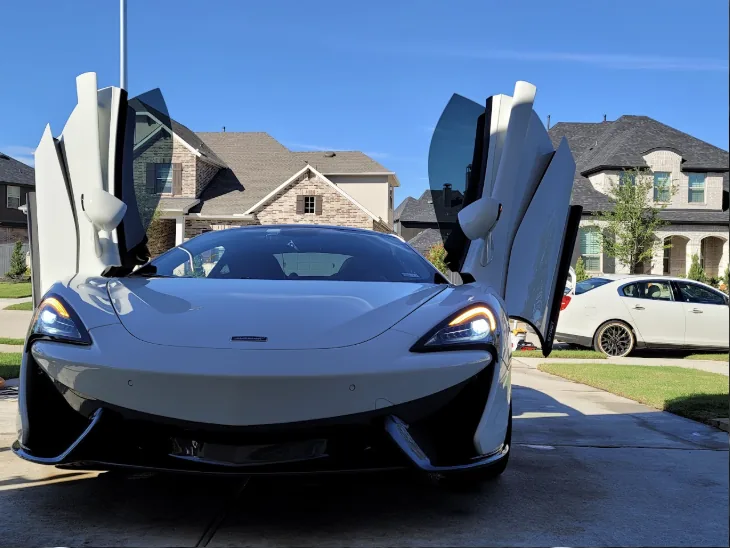 White McLaren 570GT with its doors up after a detail