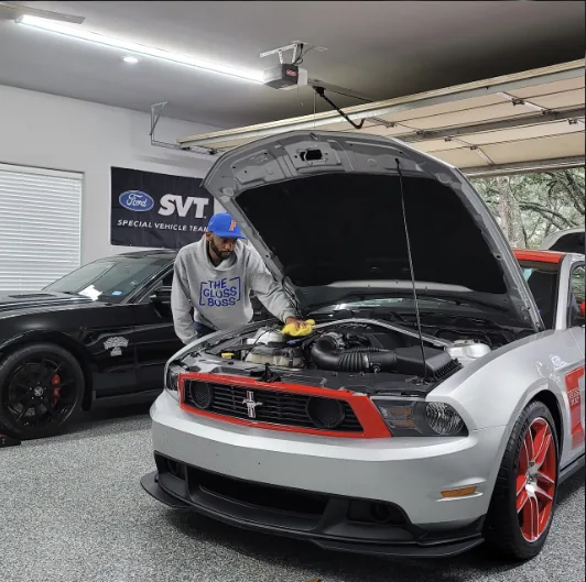 Cleaning the engine bay of a Mustang Boss 302 Laguna Seca in a home garage